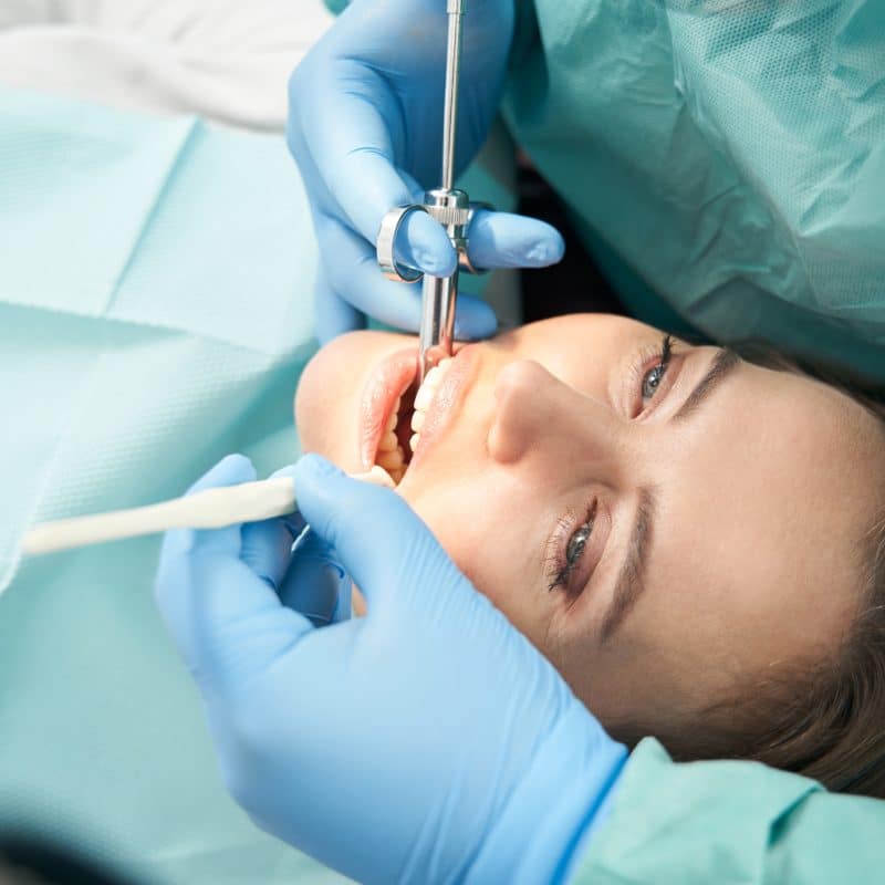 dentist performing root canal therapy on female patient