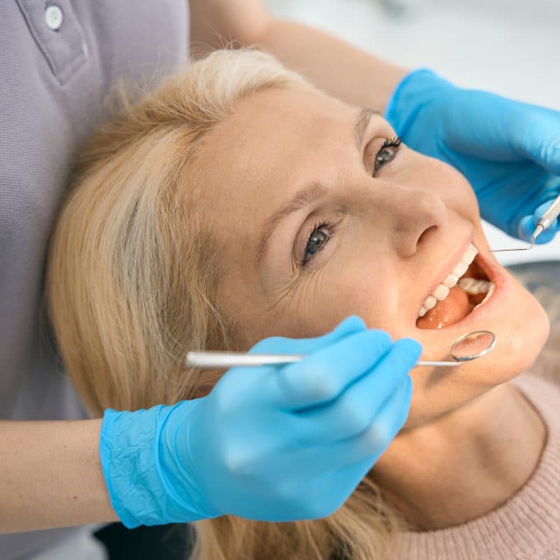 dentist inspecting a old woman's smile, clear aligner candidate
